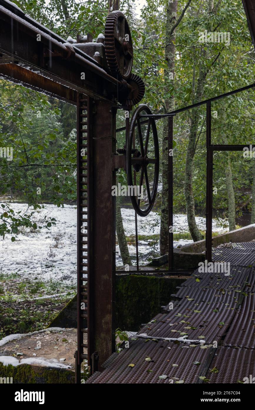 Verrouiller les roues dentées de contrôle sur un jour de pluie, photo verticale. Ancienne centrale hydroélectrique finlandaise sur la rivière Volchya. Centrale hydroélectrique de Sosnovskaya. Sosn Banque D'Images