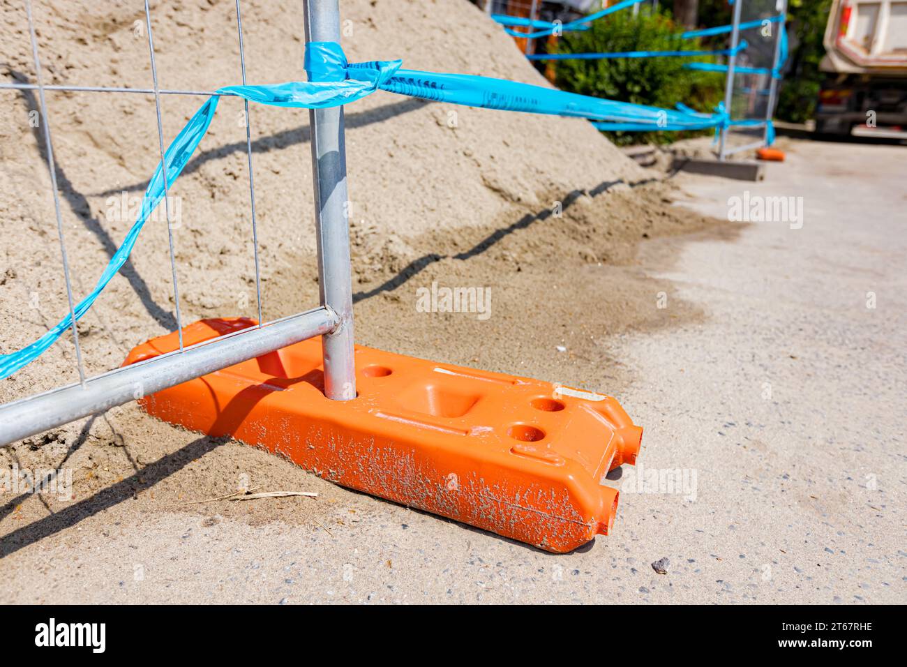 Le pied creux de clôture en plastique est pour la stabilité des panneaux temporaires de clôture en fil métallique, installés devant le chantier à côté de la rue. Banque D'Images