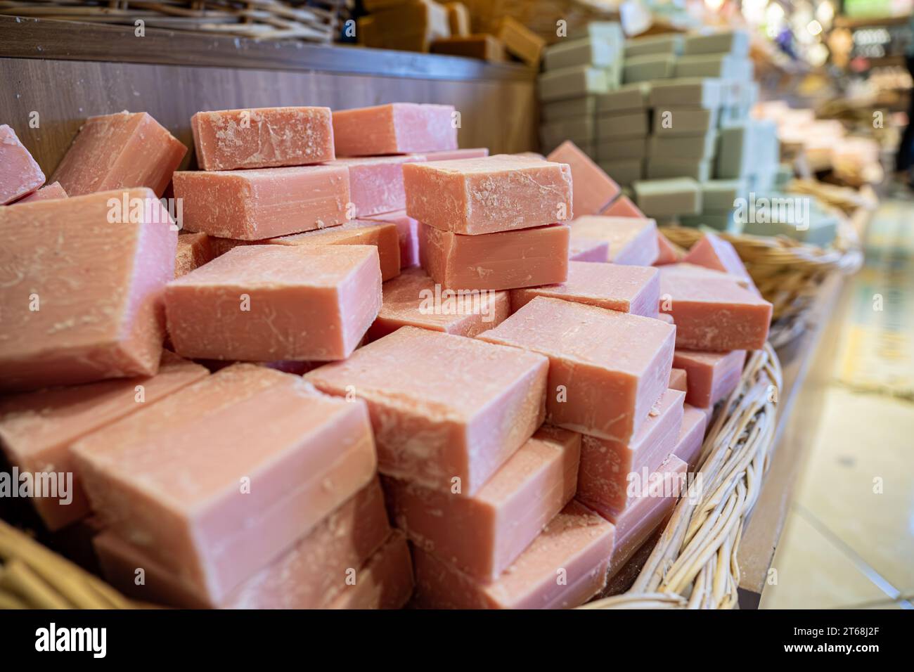 Panier fait à la main plein de savon de fleur fait à la main dans un magasin se composent de produits de soins du corps avec fond en bois Banque D'Images