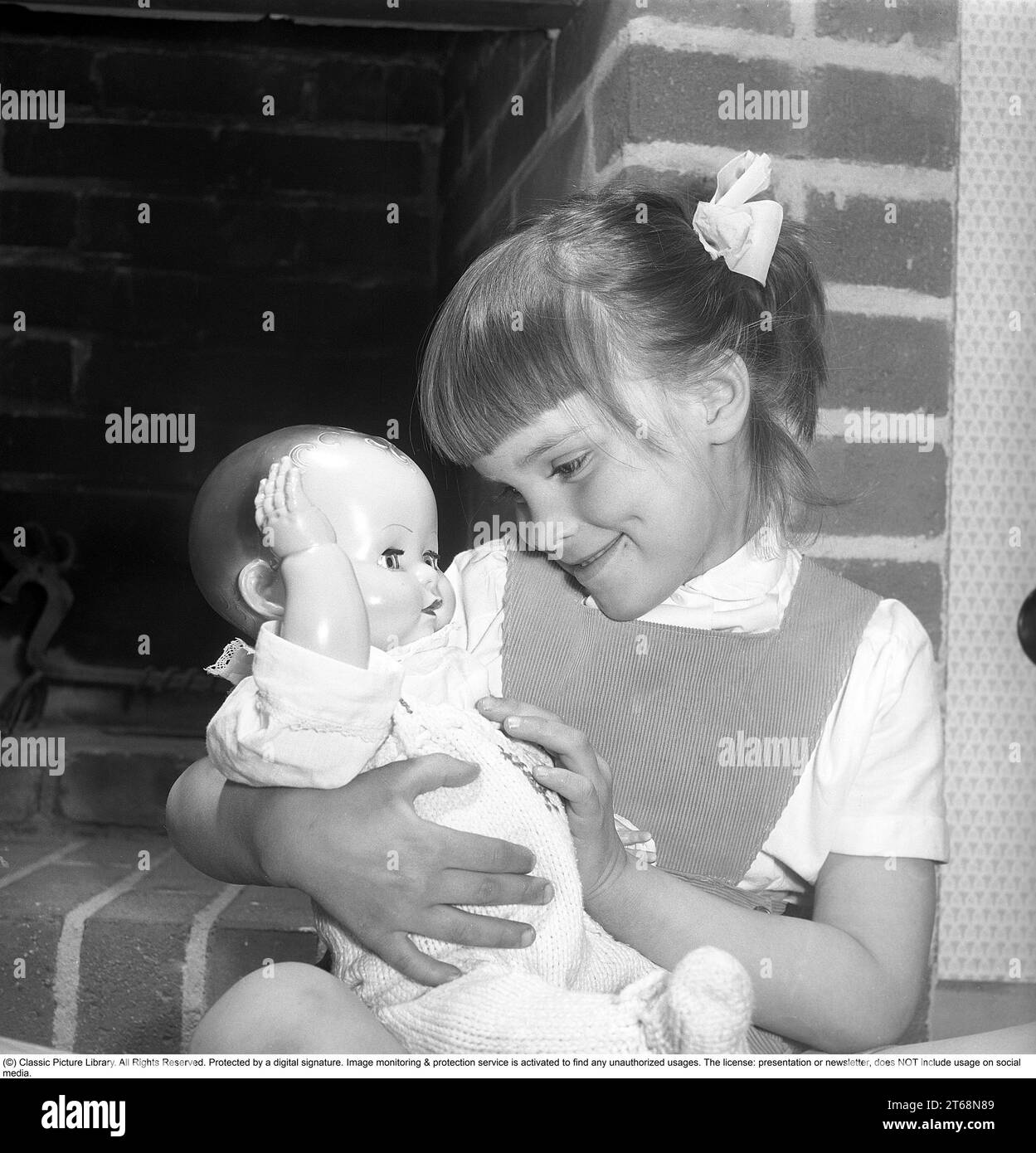 Une fille avec une poupée dans les années 1950 Une petite fille joue avec sa poupée. Suède 1956. Kristoffersson réf. BS39-11 Banque D'Images