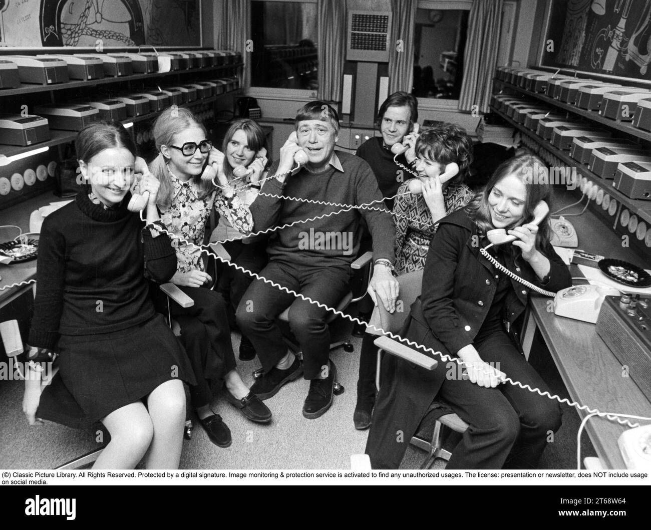 Dans les années 1970 Le présentateur radio Pekka Langer, 1919-1996 ans, ainsi que les femmes qui utilisent les téléphones pour les appels à l'émission Telefonväktarna qui pouvait recevoir jusqu'à 500 appels pendant la période où l'émission radio était en ondes. Suède 1971 Banque D'Images