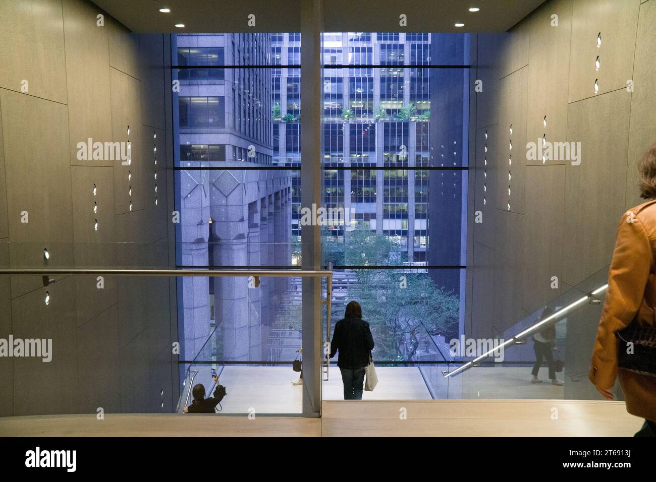 New York, États-Unis, 30 octobre 2023 : les gens admirent la vue de Midtown Manhattan à travers les fenêtres en verre plat d'une cage d'escalier à l'intérieur du MOMA. Anna Watson/Ala Banque D'Images
