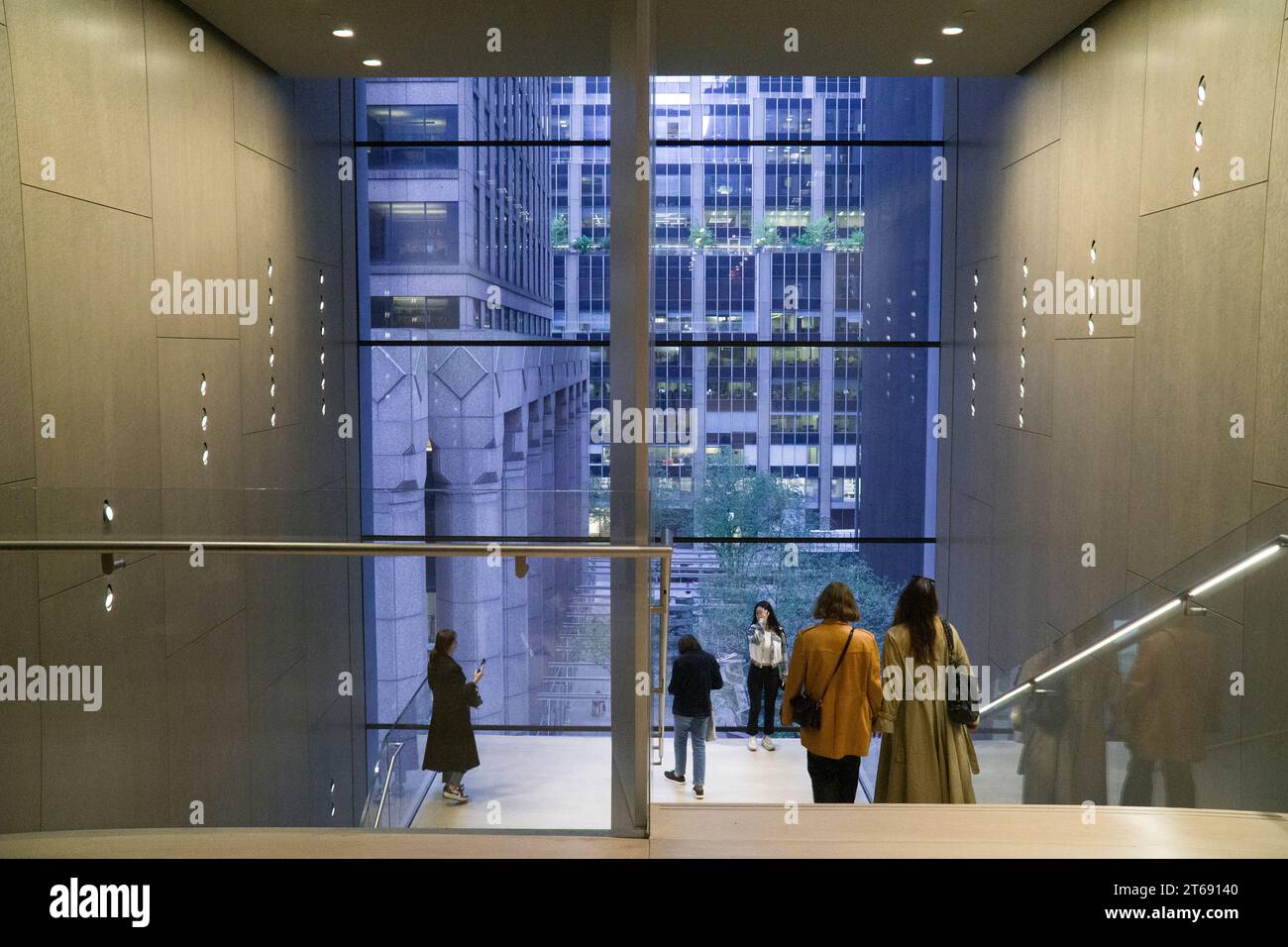 New York, États-Unis, 30 octobre 2023 : les gens admirent la vue de Midtown Manhattan à travers les fenêtres en verre plat d'une cage d'escalier à l'intérieur du MOMA. Anna Watson/Ala Banque D'Images