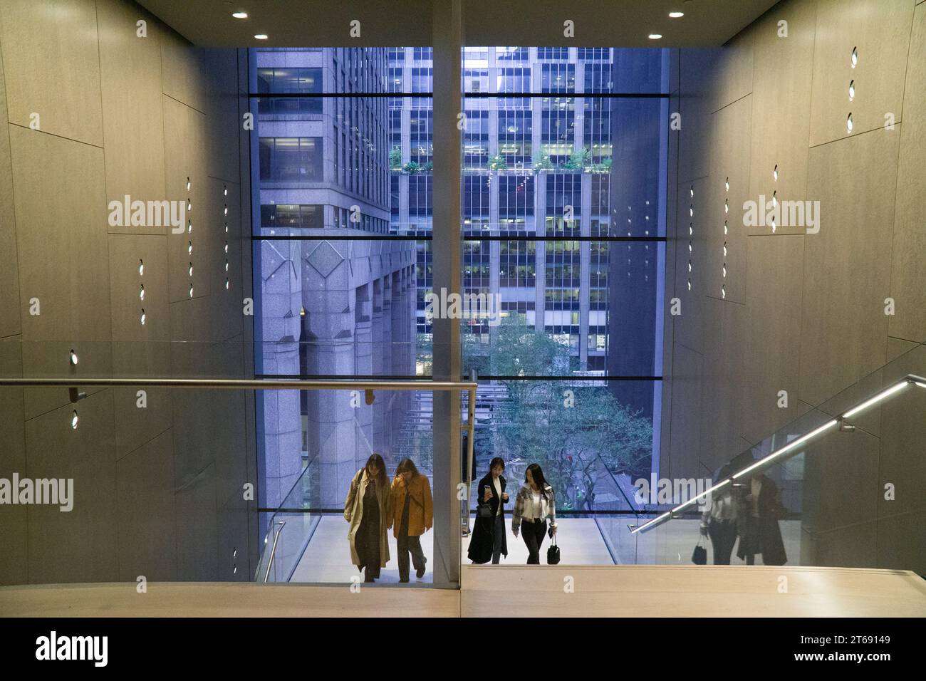 New York, États-Unis, 30 octobre 2023 : les gens admirent la vue de Midtown Manhattan à travers les fenêtres en verre plat d'une cage d'escalier à l'intérieur du MOMA. Anna Watson/Ala Banque D'Images
