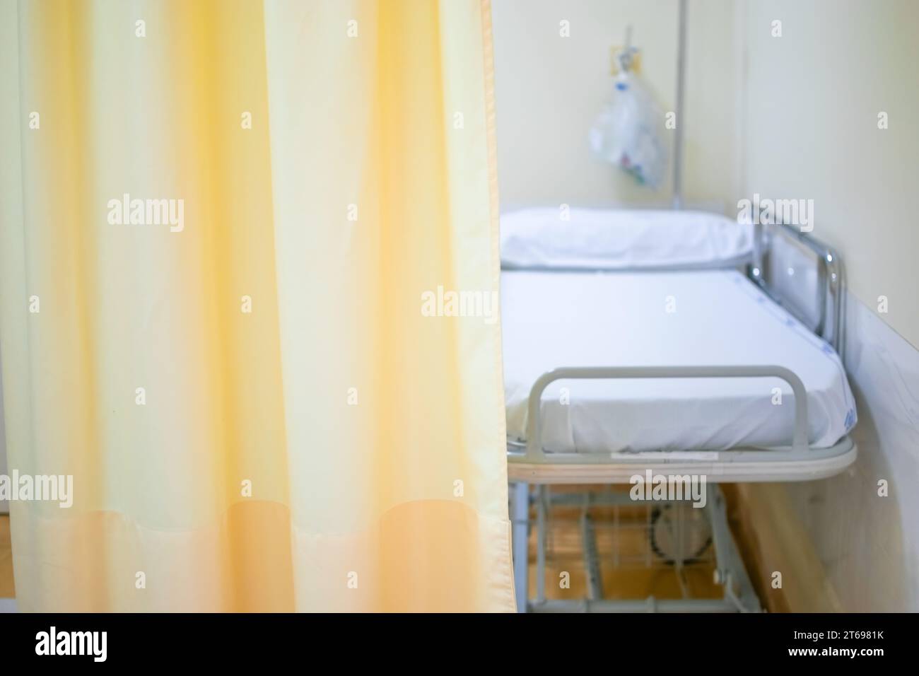 Lit d'hôpital ou civière avec rideau jaune clair comme espace de copie Banque D'Images