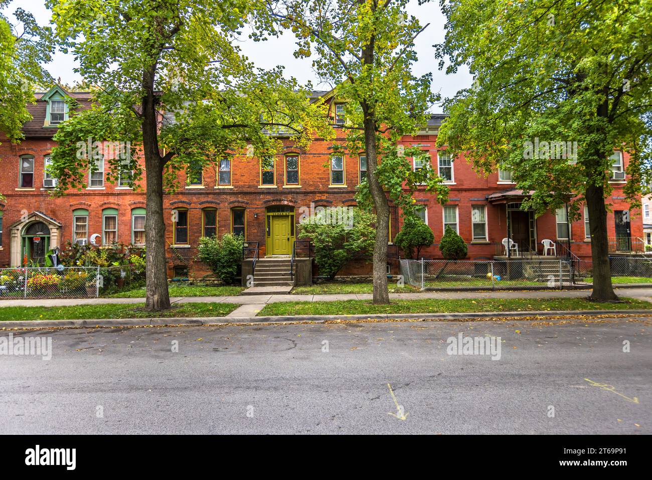 Une rue de bâtiments résidentiels avec des jardins voraces verts traverse le quartier historique de Pullman à Chicago, Illinois, États-Unis. À la fin du XIXe siècle, 20 000 personnes vivaient et travaillaient dans la ville conçue par l'entrepreneur George Pullman à partir de 1880. La beauté de la ville et le confort de l'électricité et de l'eau courante dans les maisons étaient destinés à maintenir les employés satisfaits, les décourageant de boire de l'alcool et de faire grève. Le loyer était déduit directement des salaires des travailleurs. Le quartier de Pullman à Chicago est en train de se gentrifier depuis la fin du XXe siècle, avec de nombreux Banque D'Images