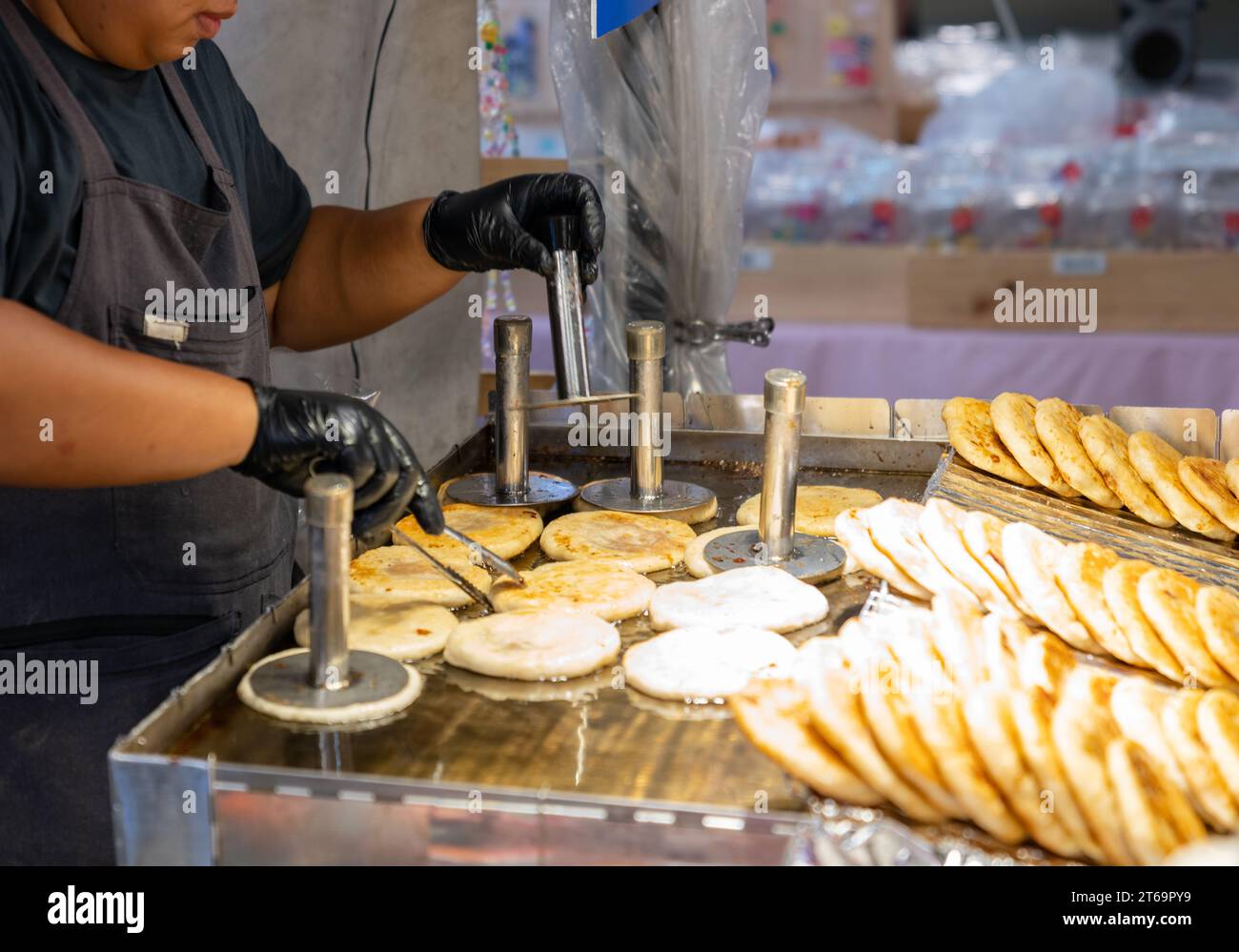 Pâte à base de farine fermentée façonnée en boules, remplie d'une cuillerée de cassonade, et frite dans une poêle préchauffée. Banque D'Images