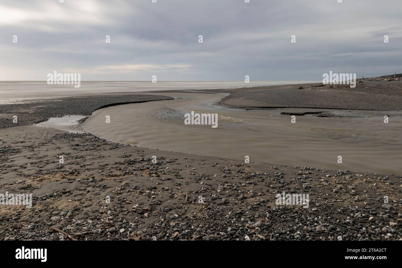 Tournage de longue durée au ruisseau Mangaone à te Horo Beach, Kapiti, Nouvelle-Zélande. les vagues sont aplaties et l'eau est laiteuse Banque D'Images