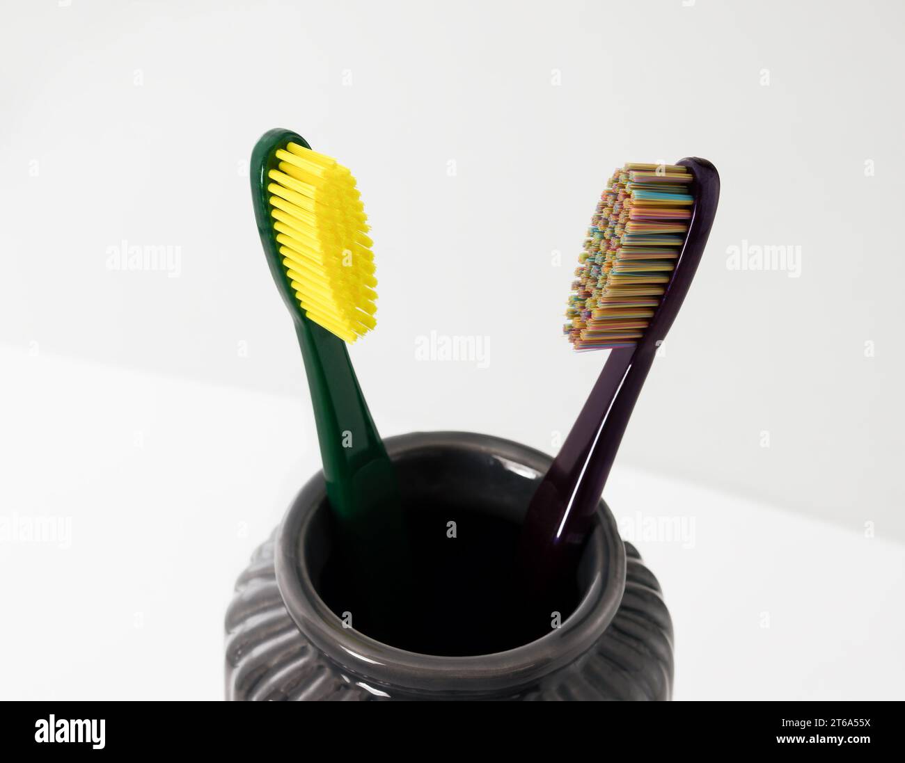 Brosses à dents dans un bol en céramique sur fond flou. Brosses à dents colorées, concept de dents saines. Banque D'Images Brosses à dents dans un bol en céramique sur fond flou. Brosses à dents colorées, concept de dents saines. Banque D'Images