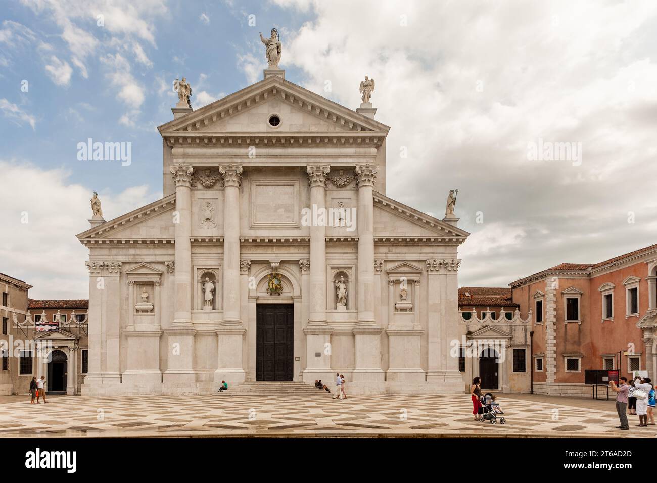 Les touristes se promènent devant la Basilique de San Giorgio Maggiore à Venise, vue de face. Banque D'Images