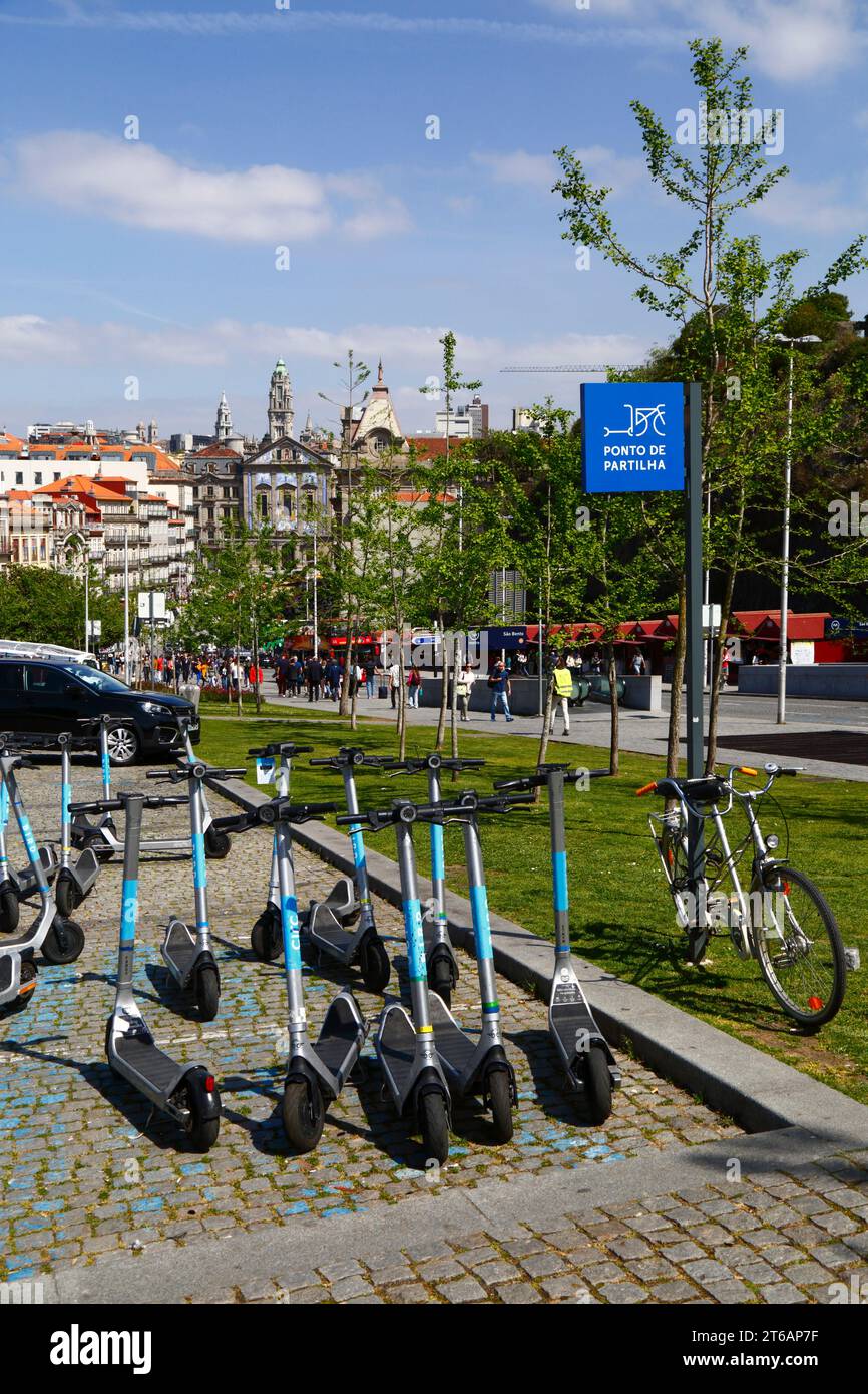 Scooters électriques garés au point de partage, église Igreja dos Congregados et tour de la mairie à distance, Ribeira, Porto / Porto, Portugal Banque D'Images