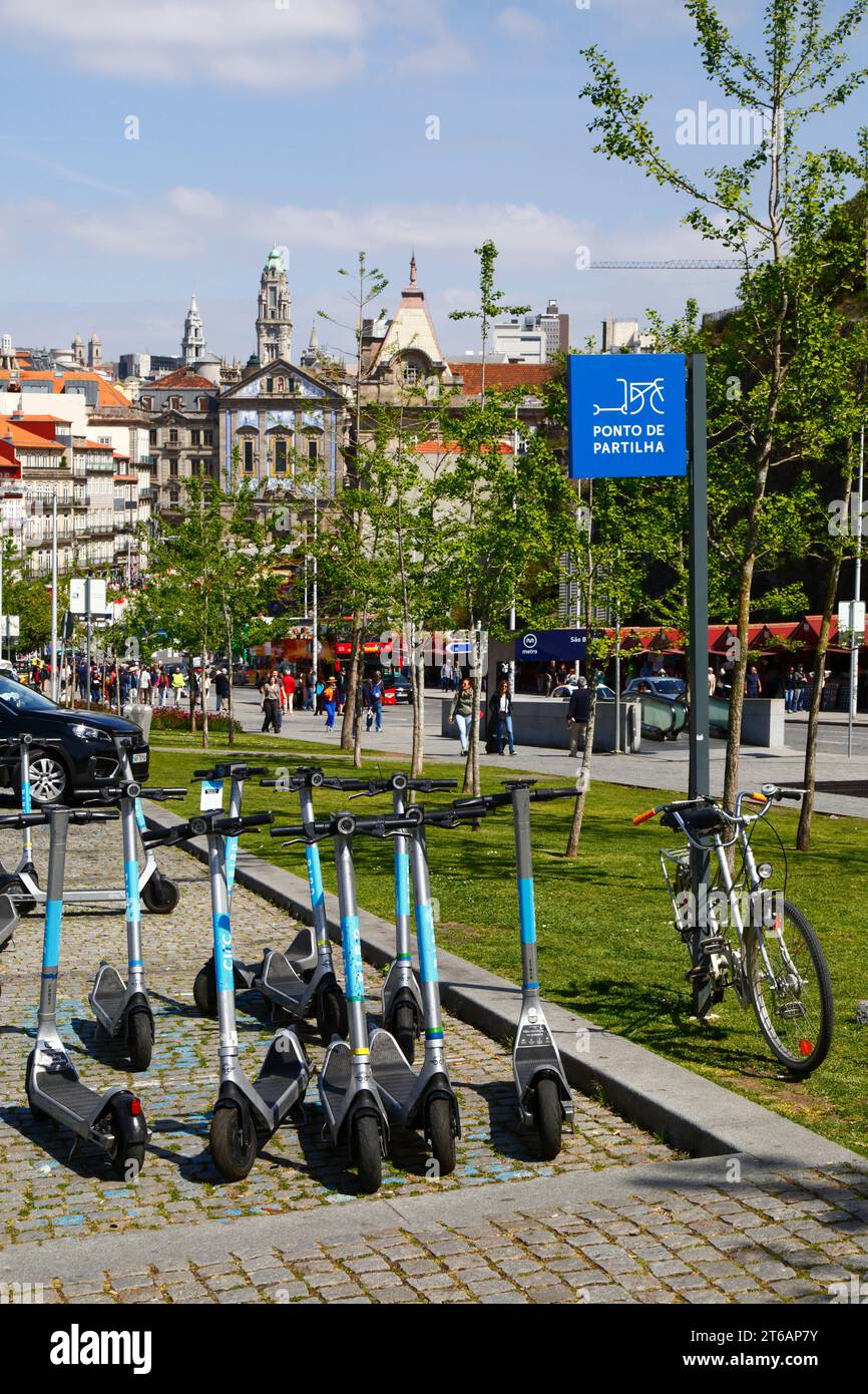 Scooters électriques garés au point de partage, église Igreja dos Congregados et tour de la mairie en arrière-plan, Ribeira, Porto / Porto, Portugal Banque D'Images