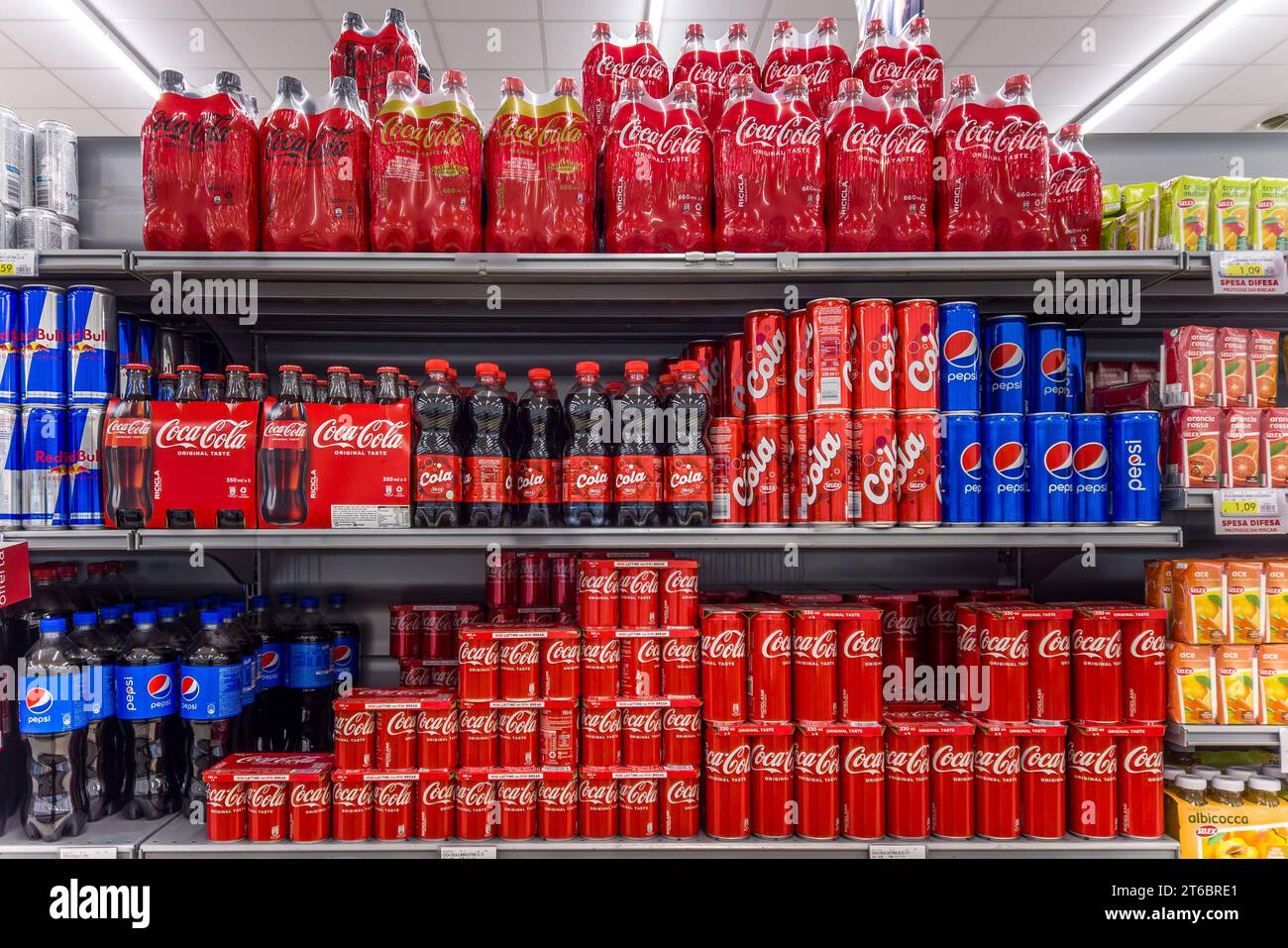 Italie - 09 novembre 2023 : Coca Cola en bouteilles en plastique, canettes et bouteilles en verre avec bouteilles Pepsi Cola emballées et canettes sur des étagères à vendre en Italie Banque D'Images