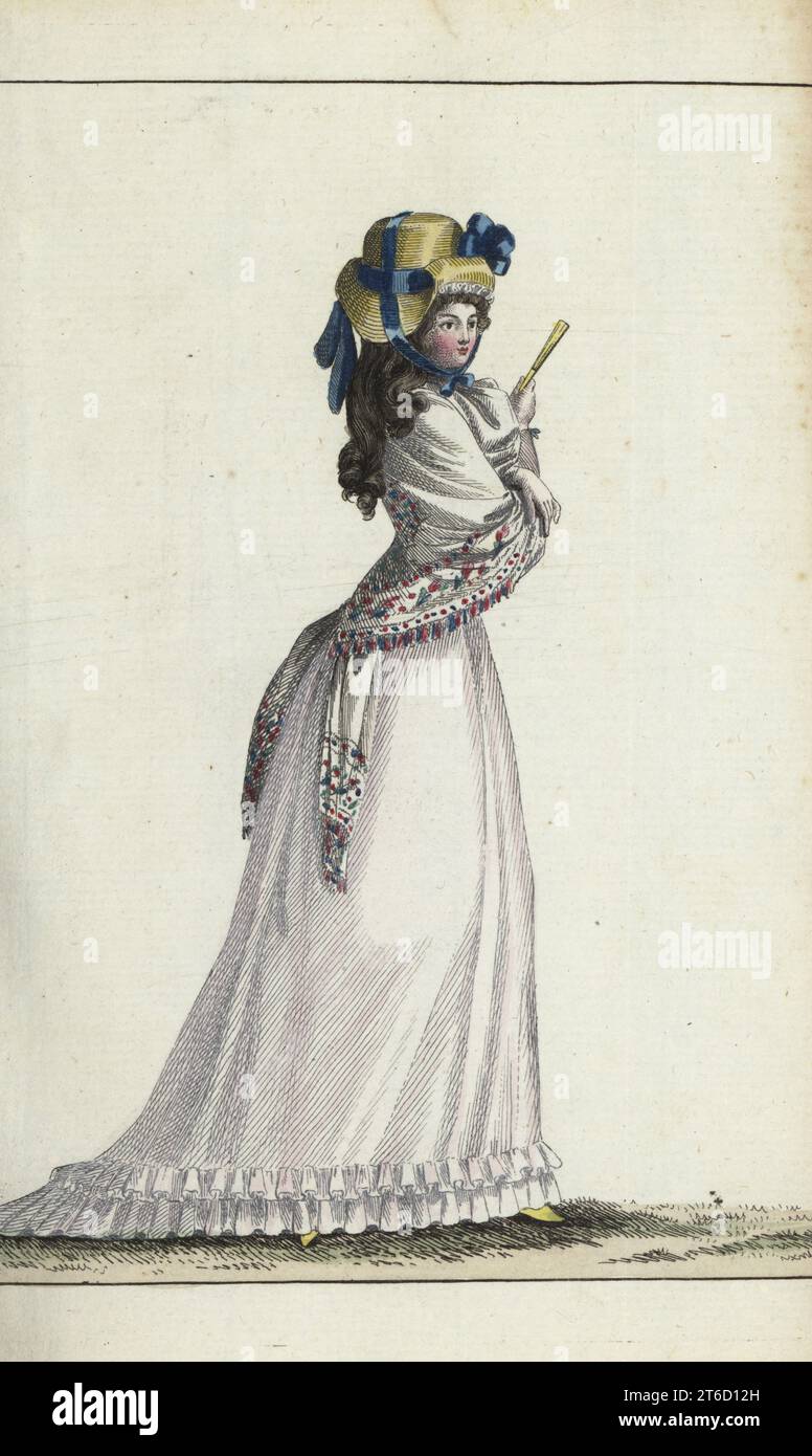 Femme anglaise en bonnet de paille avec ruban bleu et cocarde, grand châle, fourreau de mousseline, éventail jaune et pantoufles. Gravure sur cuivre colorée à la main de Jean-Antoine le Brun ou Lebrun-Tossas Journal de la mode et du gout, anciennement Cabinet des modes, chez Buisson, Paris, et Joseph le Boffe, Londres, 11è Cahier, 5 juin 1790. Banque D'Images