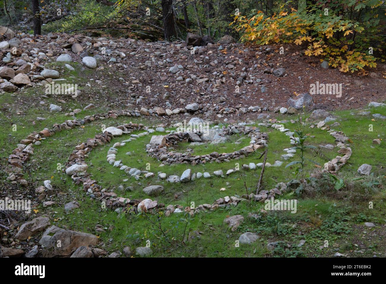 Art environnemental, un motif en spirale construit à partir de rochers dans la nature sauvage du comté de Butte, l'œuvre d'art en pierre se démarque dans la forêt. Banque D'Images