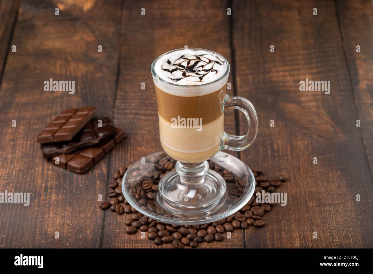 Latte à café multicouche dans une tasse en verre sur une table en bois Banque D'Images