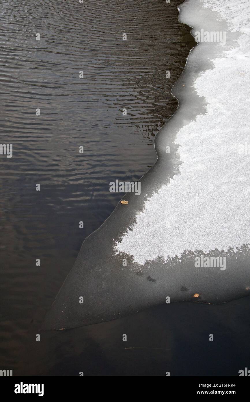 La glace flotte sur l'eau sombre Banque D'Images