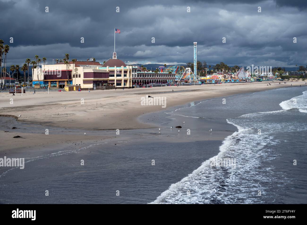 Santa Cruz, États-Unis - 05,02,2023 : Parc d'attractions situé à côté de la plage de sable près de la mer ondulante sous un ciel nuageux orageux Banque D'Images