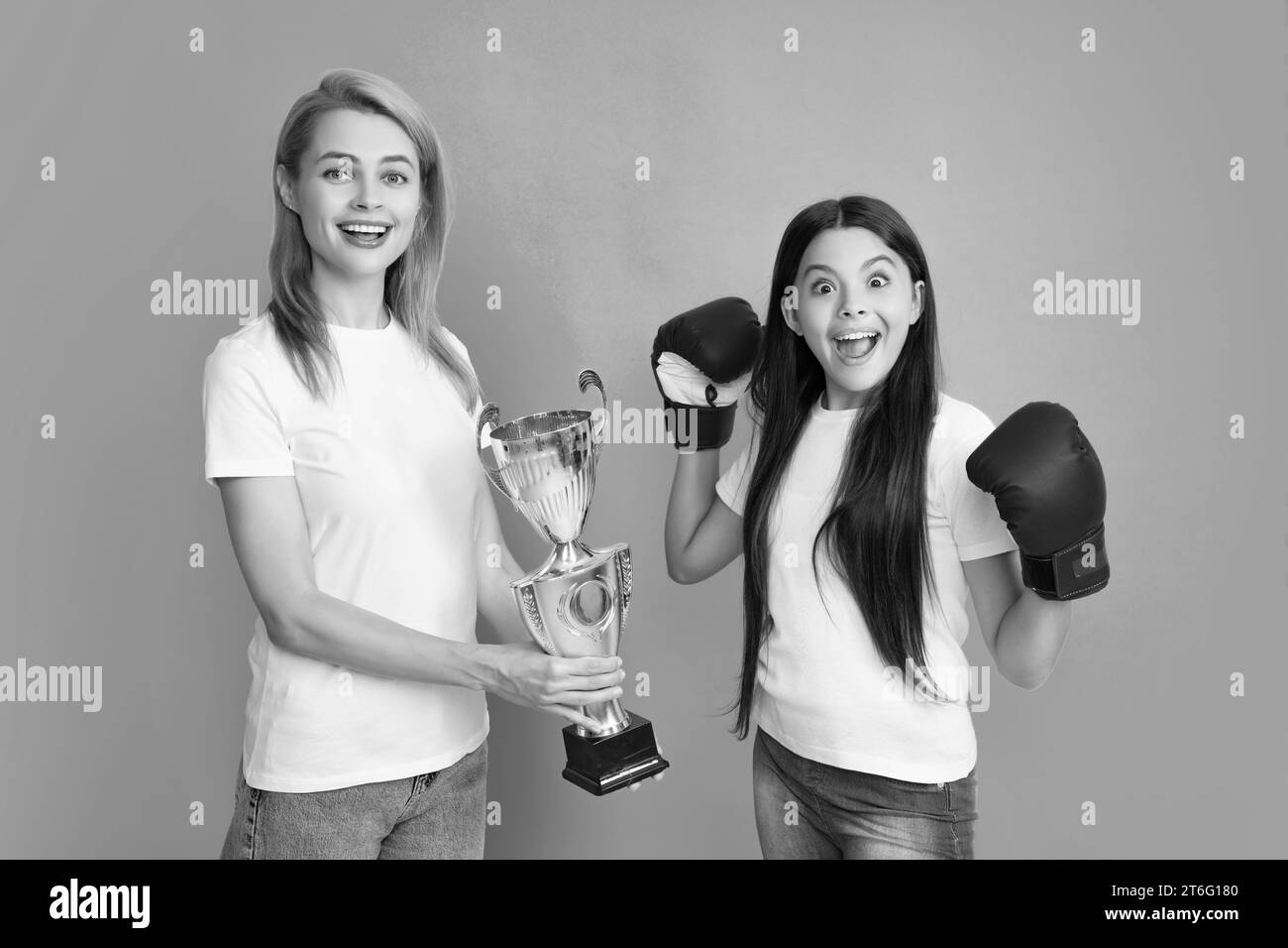 Boxer gagnant adolescent. Maman et fille adolescente tenant le prix gagnant, montrant le trophée sur fond bleu. Fille de soutien de parent Banque D'Images