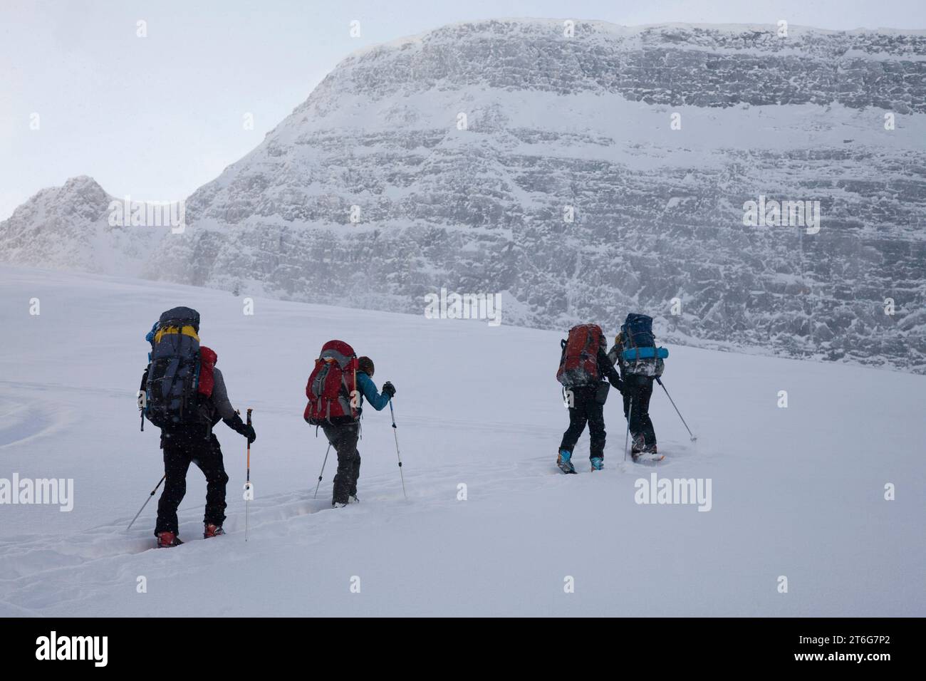 Quatre skieurs de l'arrière-pays grimpent une pente en hiver. Banque D'Images