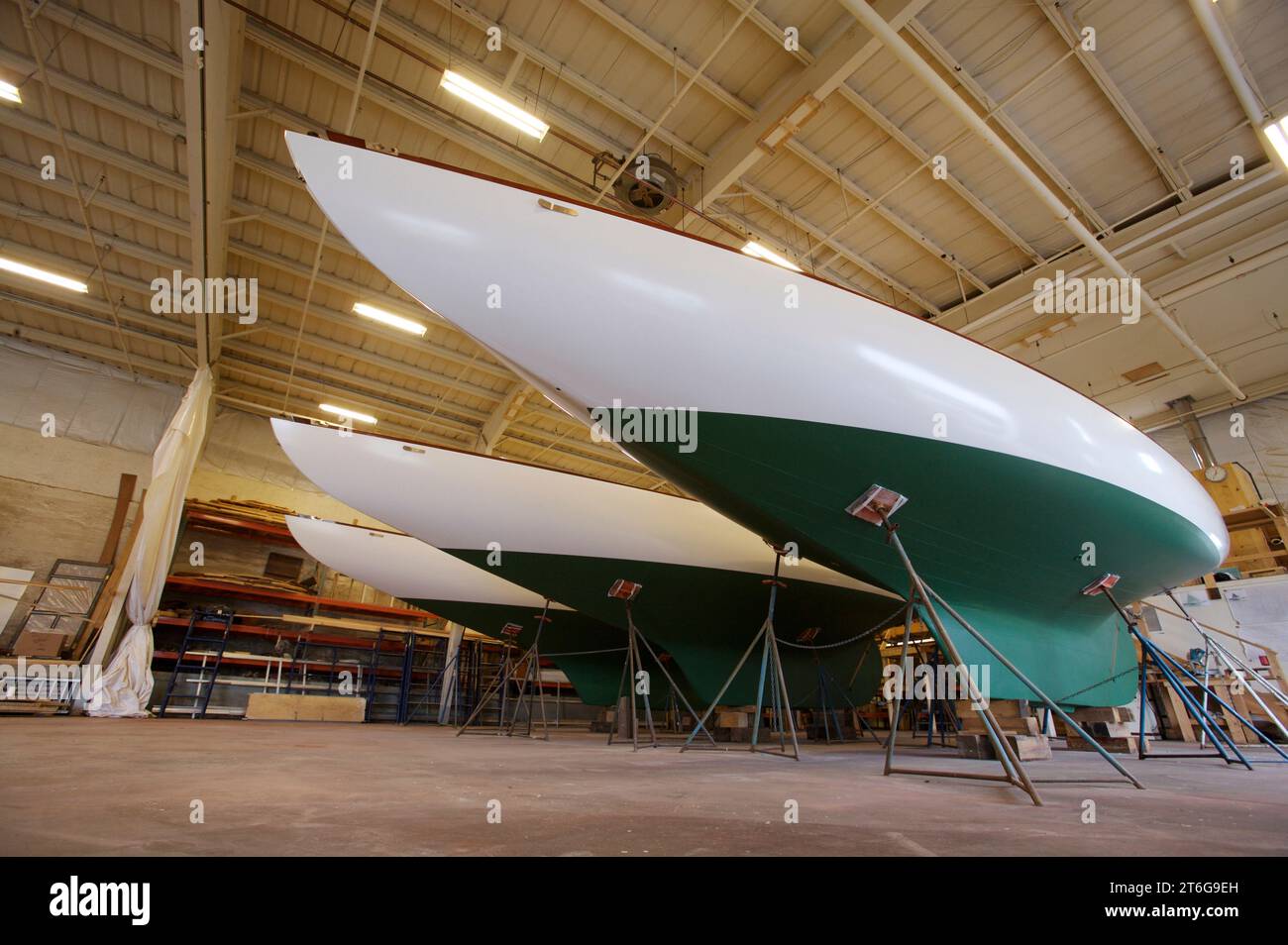 Trois yachts à voile classiques sont vus à l'intérieur d'un hangar à bateaux lors de la dernière étape de leur restauration. Banque D'Images