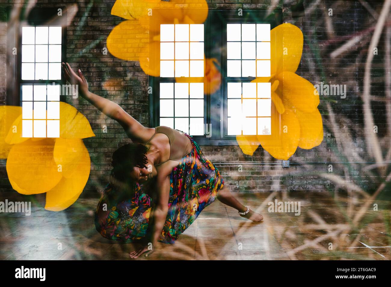 Danseuse noire posée dans le bâtiment avec exposition de fleurs plus Banque D'Images