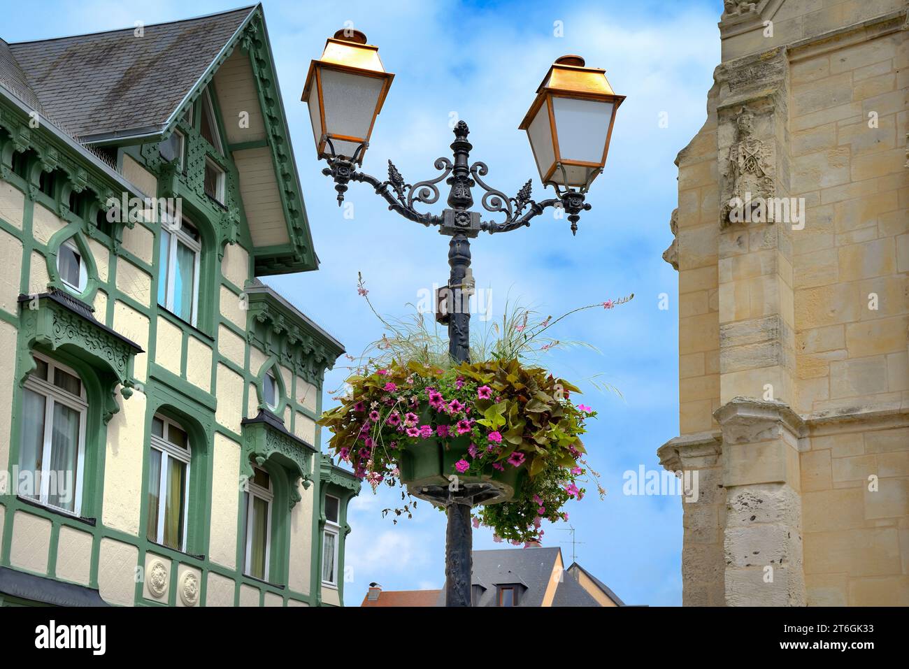 Maison à ossature en bois sculpté ornée avec travail en plâtre à motifs et lampadaire en fonte orné de fleurs, place Saint Léonard, Honfleur, Normandie, France Banque D'Images