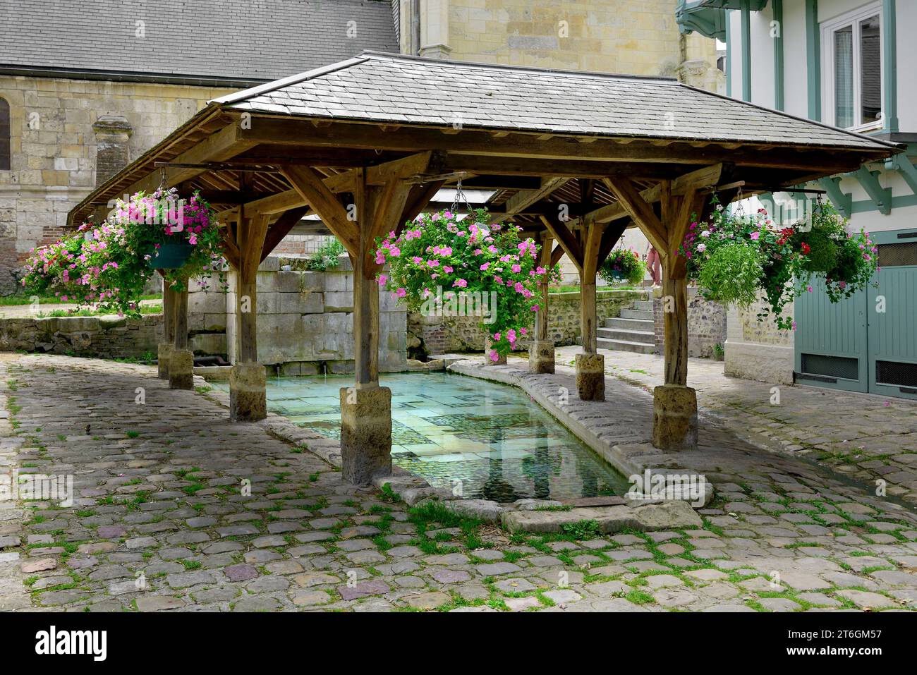 Lavoir public à ossature bois en plein air (Lavoir) avec paniers suspendus de fleurs colorées, place Saint Léonard, Honfleur, Normandie, France Banque D'Images