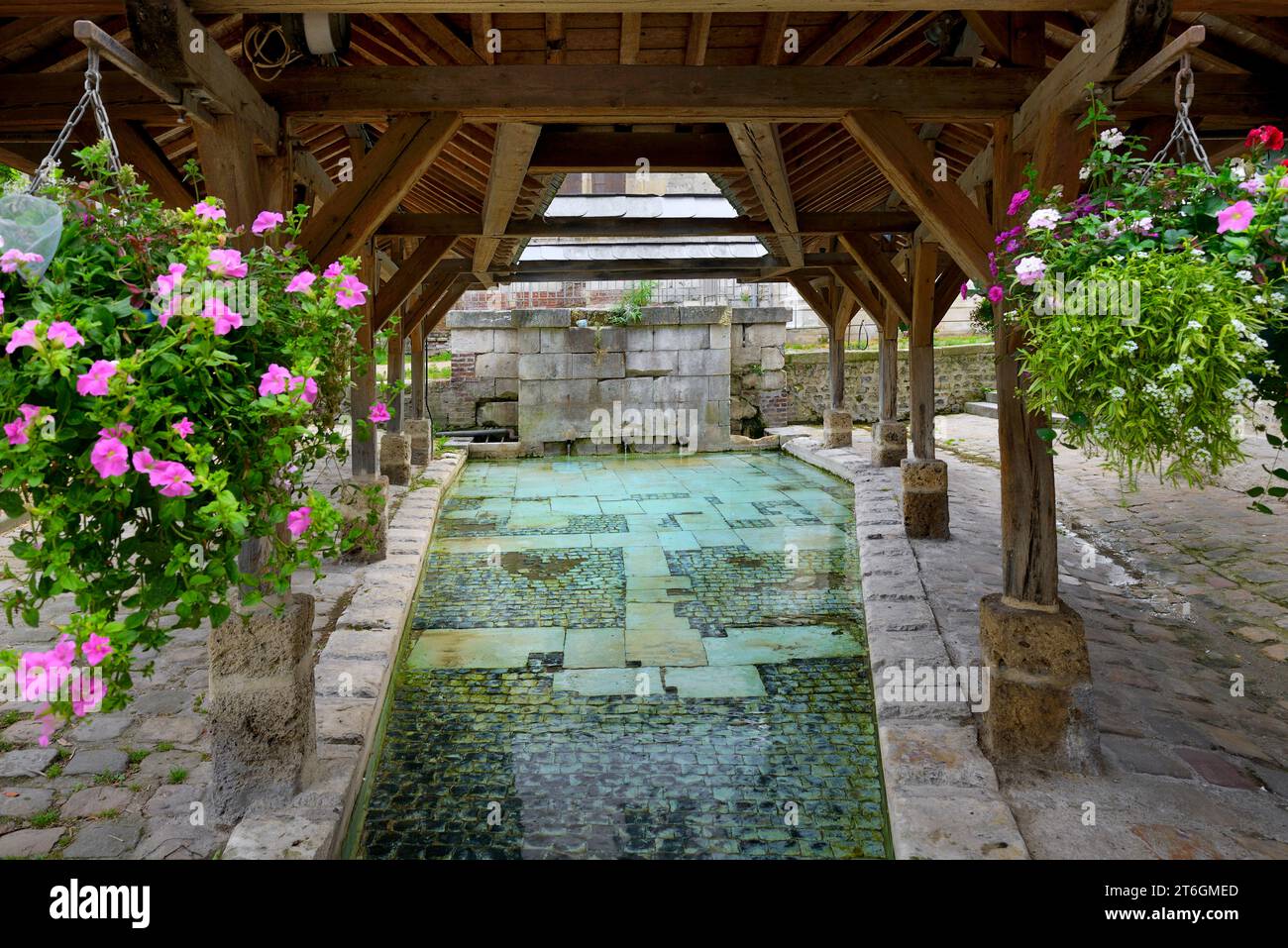 Lavoir public à ossature bois à ciel ouvert (Lavoir) avec paniers suspendus de fleurs colorées, Lavoir, place Saint Léonard, Honfleur, Normandie, France Banque D'Images