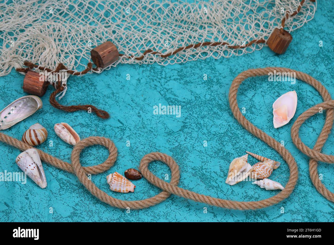 Fond bleu profond avec coquillages, corde et filet de poisson Banque D'Images