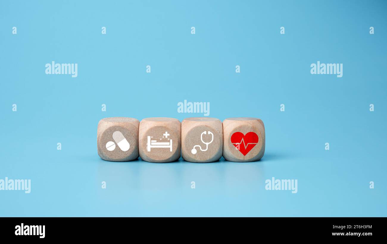 Blocs en bois avec des icônes de symbole médical sur fond bleu représentant le concept de santé avec le traitement et la médecine. Banque D'Images