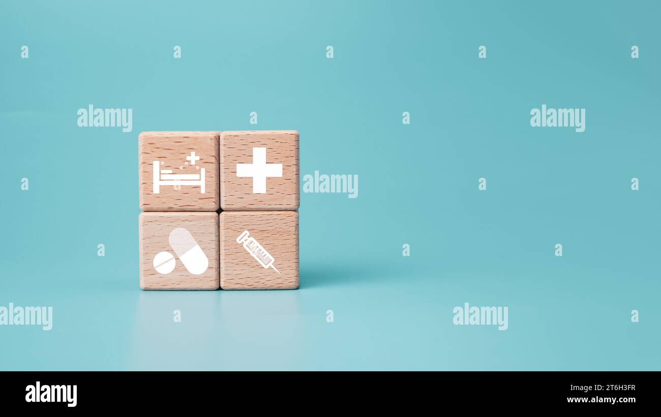 Blocs en bois avec des icônes de symbole médical sur fond bleu représentant le concept de santé avec le traitement et la médecine. Banque D'Images