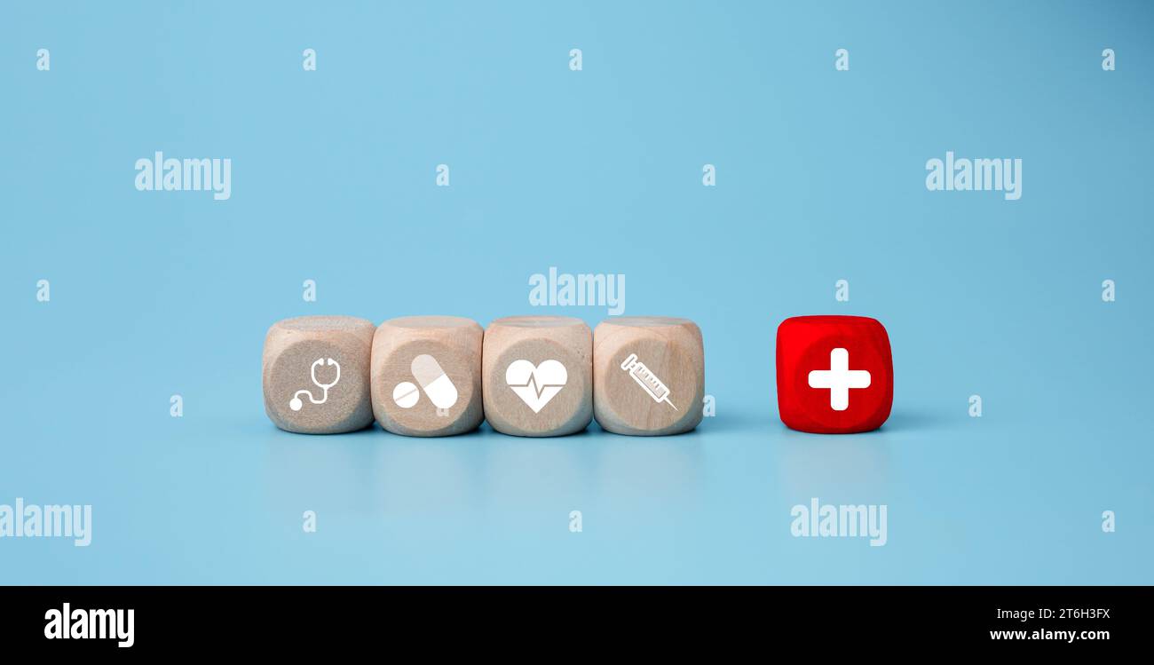 Blocs en bois avec des icônes de symbole médical sur fond bleu représentant le concept de santé avec le traitement et la médecine. Banque D'Images