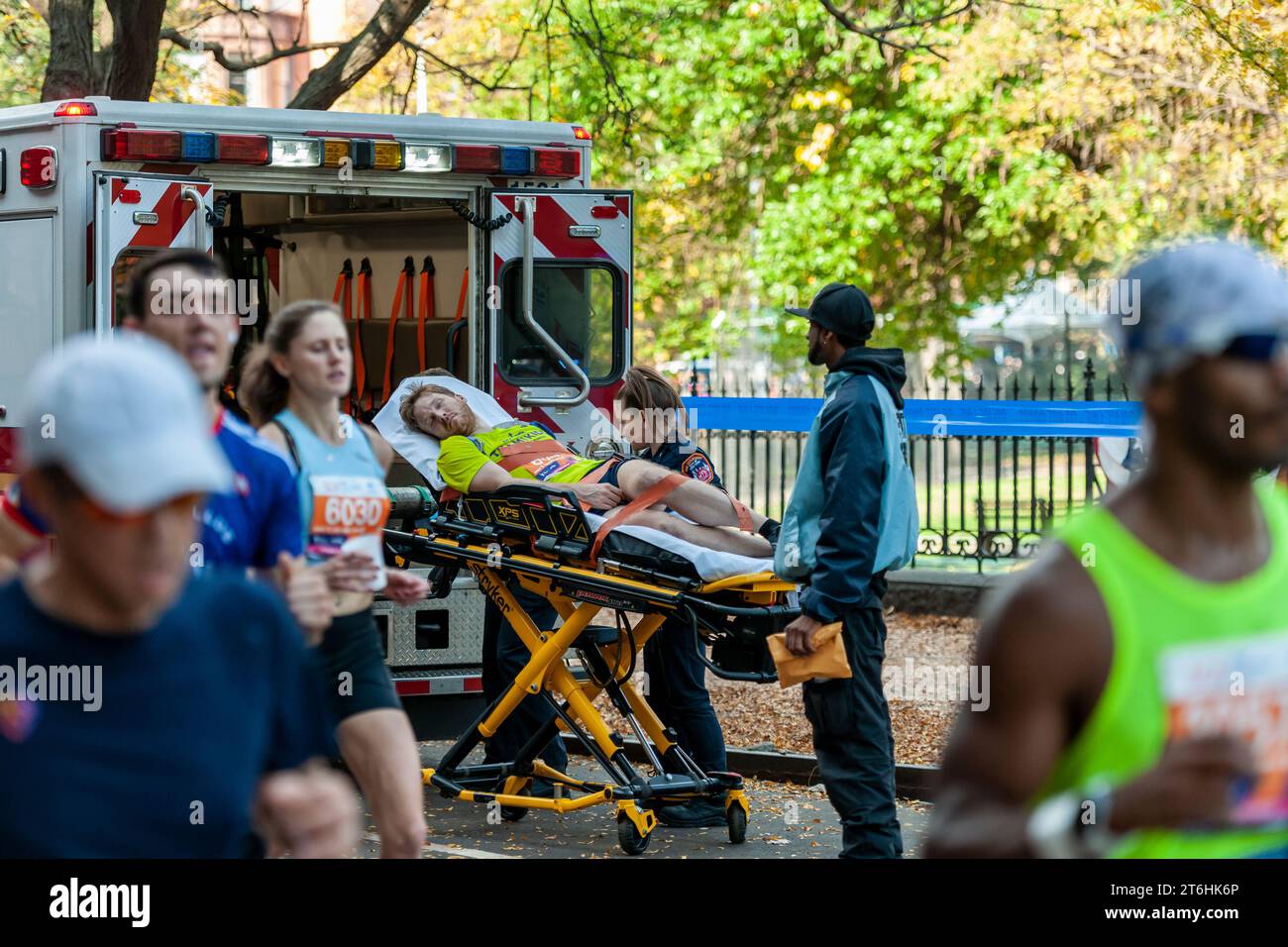 Les EMT chargent un coureur dans leur ambulance alors que les coureurs traversent Harlem à New York près de la marque des 22 miles près du parc Mount Morris lors de la course du marathon de New York du TCS le dimanche 5 novembre 2023. (© Richard B. Levine) Banque D'Images