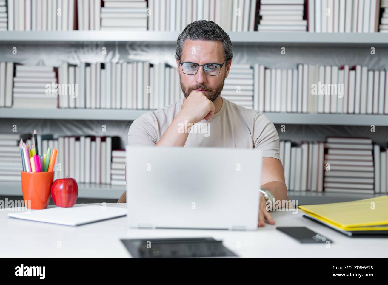 Journée des enseignants. Enseignant utilisant un ordinateur portable dans la salle de classe de l'école. Connaissance et éducation avec enseignant d'âge moyen. Professeur millénaire avec livre. Enseignants de Banque D'Images