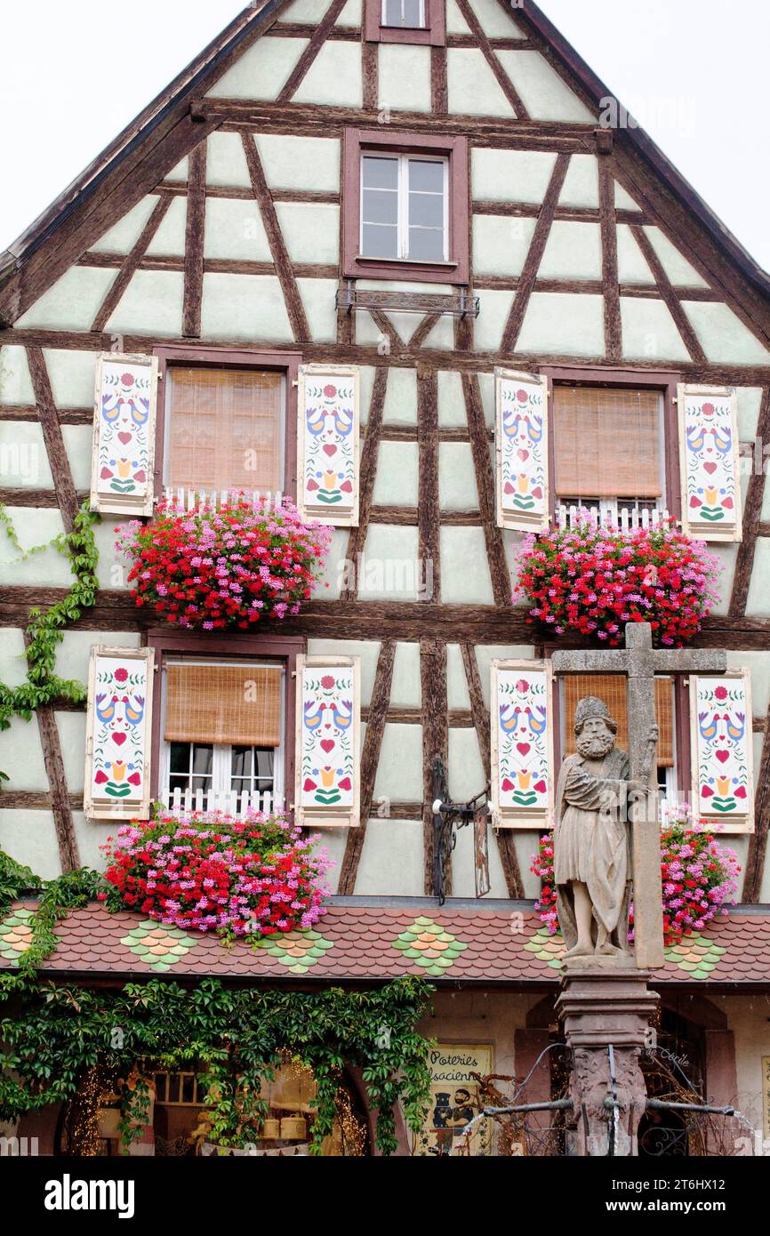 La maison à colombages 'Loewertt' du 16e siècle avec des volets peints en couleurs et la fontaine Konstatin à Kaysersberg, Alsace Banque D'Images