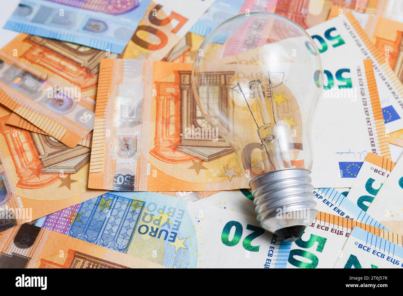 Ampoule sur une pile de billets en euros, concept d'augmentation du prix de l'électricité Banque D'Images