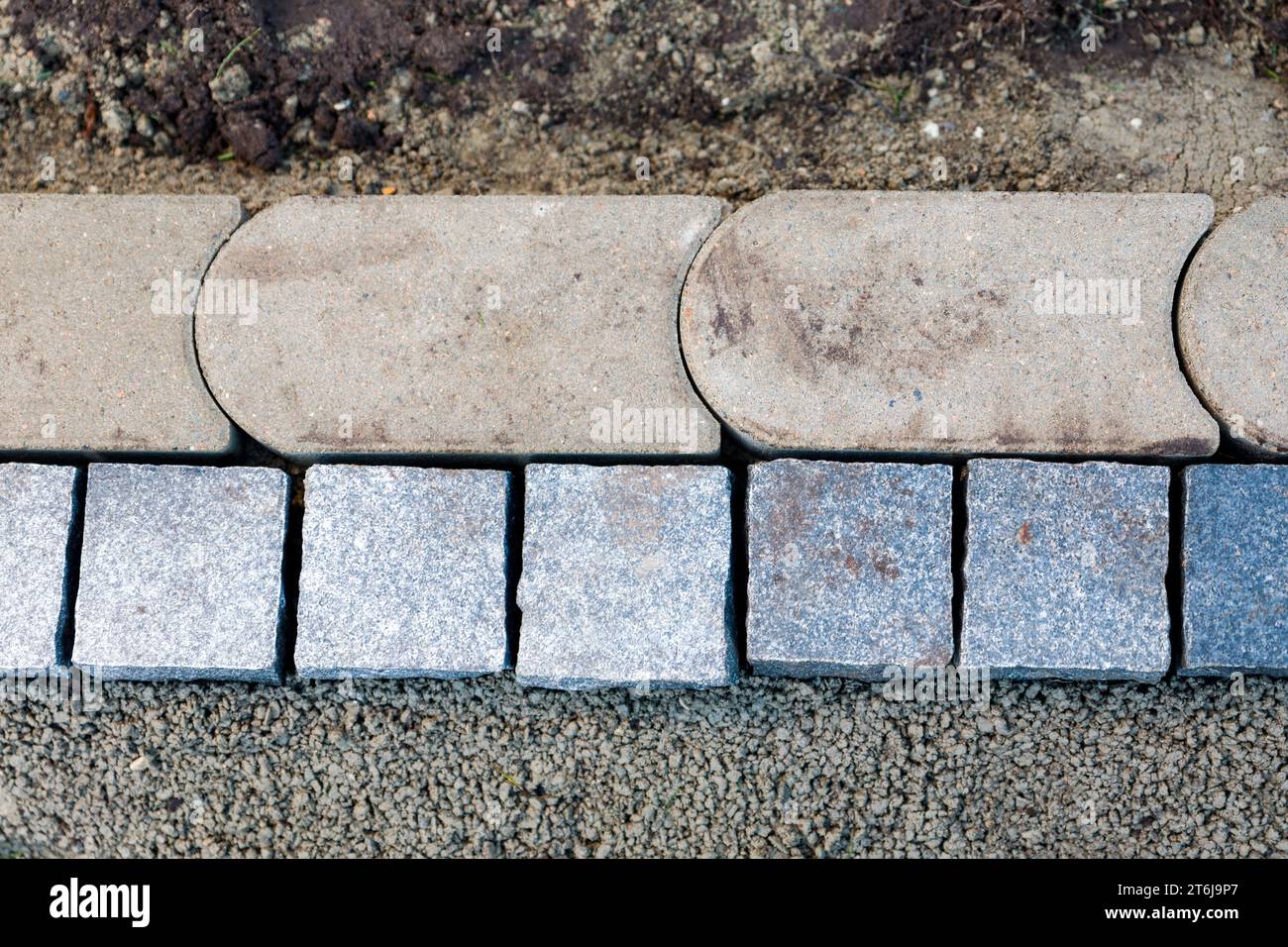Conception de jardin, pose de nouvelles pierres de bordure dans un lit de mortier. Banque D'Images