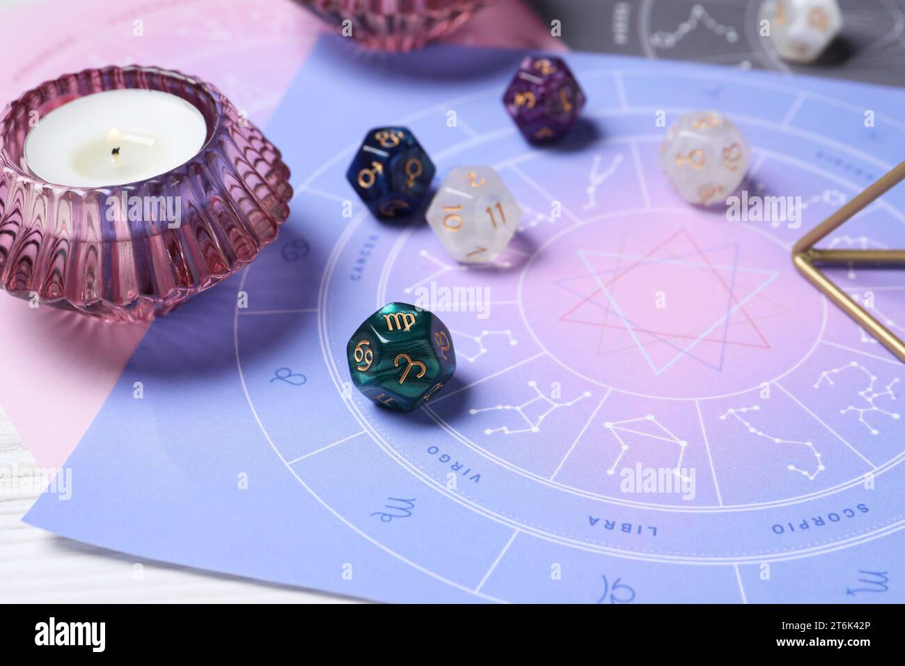 Roue du zodiaque, dés d'astrologie et bougie allumée sur la table, gros plan Banque D'Images
