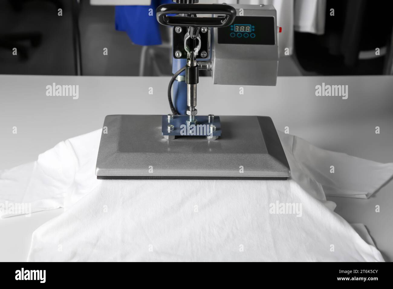 Impression du logo. Presse à chaud avec t-shirt sur table blanche Banque D'Images