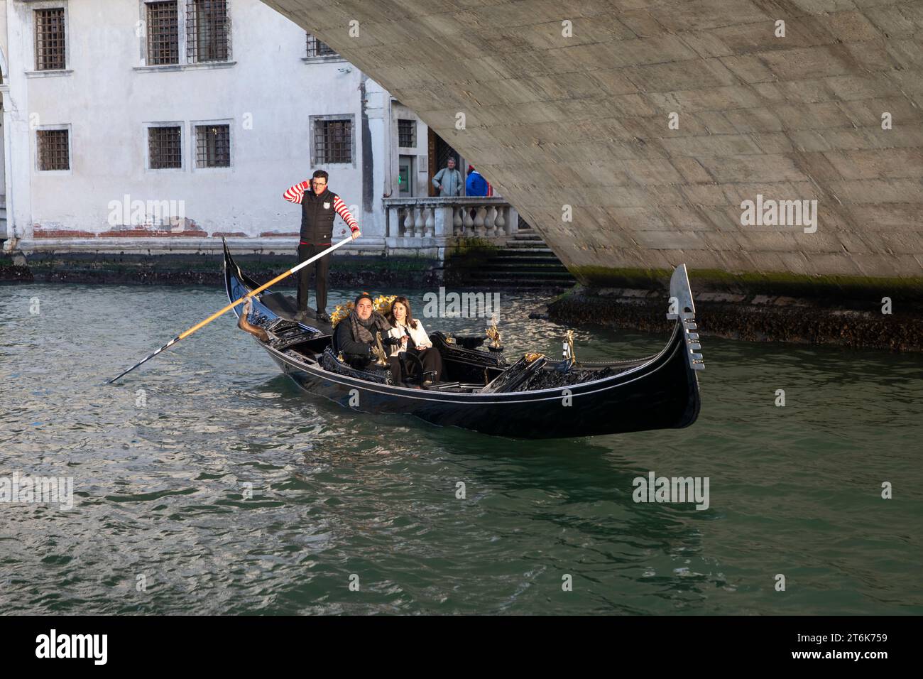 Venise, Italie. Touristes à cheval en gondole au Grand Canal explorant la ville de Venise. Banque D'Images