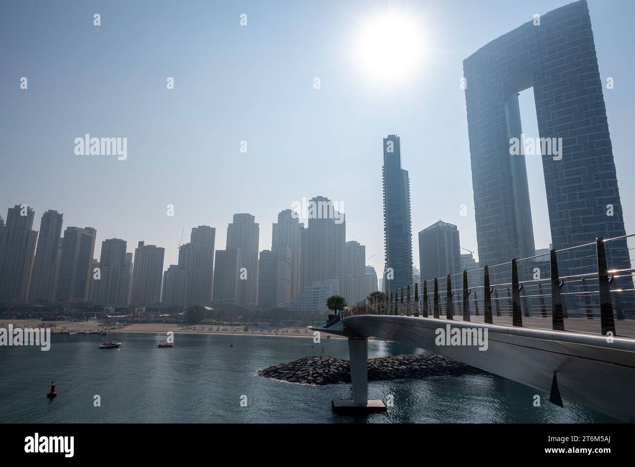 Silhouette de la ville de Dubaï et mer derrière les pistes cyclables en terrasse à colombages dans Dubai Blue Waters Island lumière du jour ciel brumeux. Banque D'Images