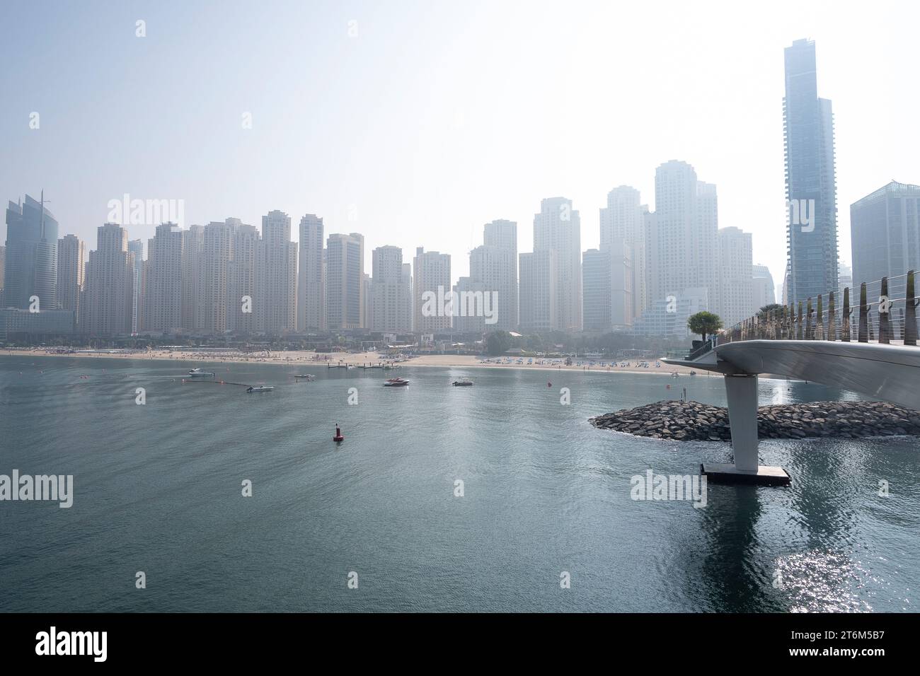 Silhouette de la ville de Dubaï et mer derrière les pistes cyclables en terrasse à colombages dans Dubai Blue Waters Island lumière du jour ciel brumeux. Banque D'Images