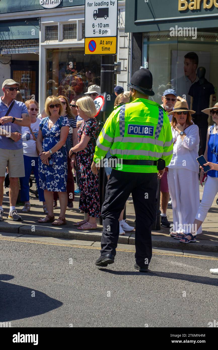 15 juin 2023 Un agent de police en uniforme en service de rue dirige les touristes près du château de Windsor qui est une célèbre résidence royale à Windsor Berkshi Banque D'Images