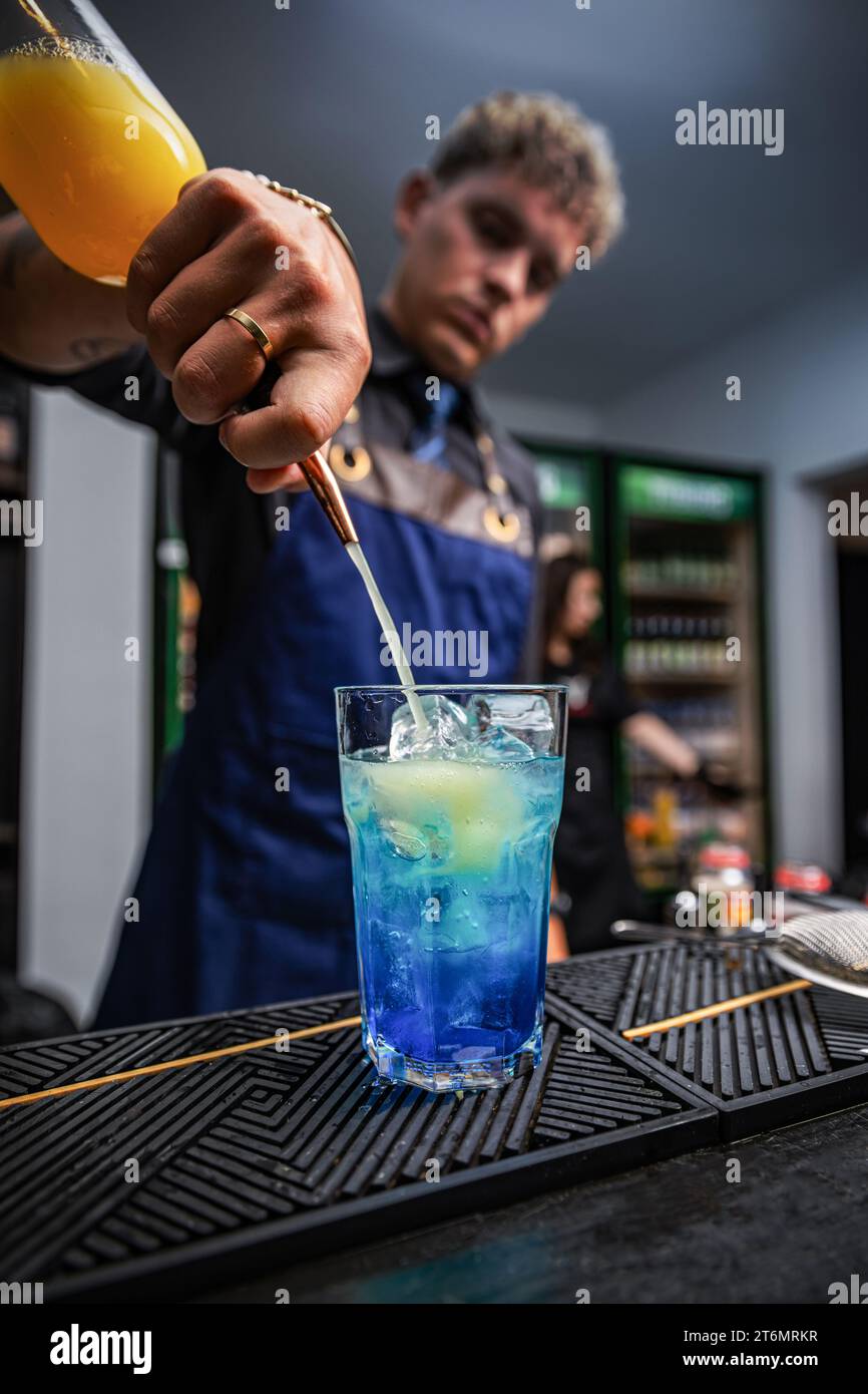 Barman professionnel préparant un cocktail au comptoir du bar. Détails de la mixologie Banque D'Images