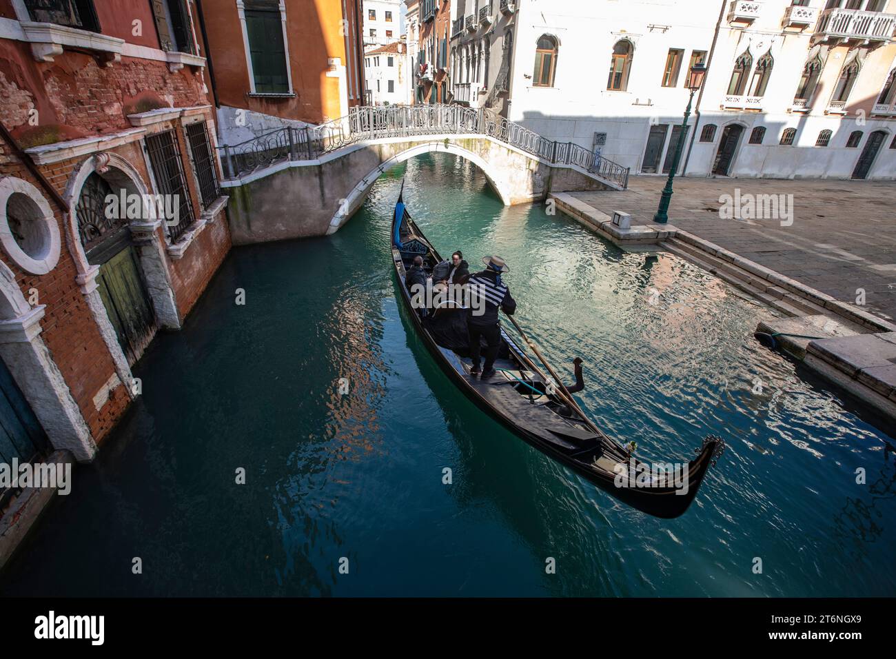 Venise, Italie. Touristes à cheval en gondole à un canal explorant la ville de Venise. Banque D'Images