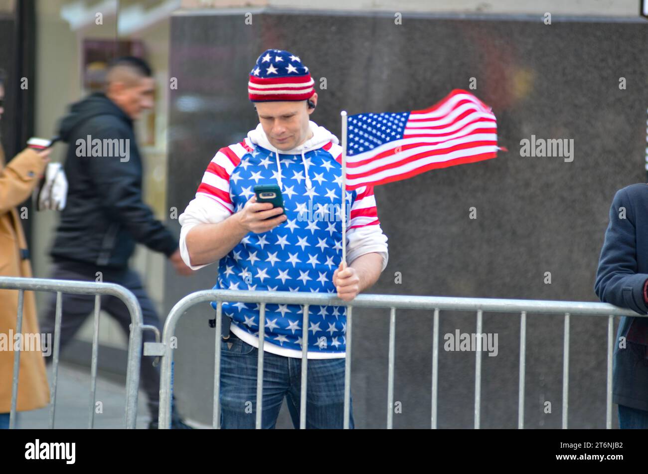 New York, États-Unis. 11 novembre 2023. Spectateurs vus avec des drapeaux américains sur le côté de la rue lors de la parade annuelle de la Journée des vétérans le long de la 5e Avenue à New York. Crédit : Ryan Rahman/Alamy Live News Banque D'Images