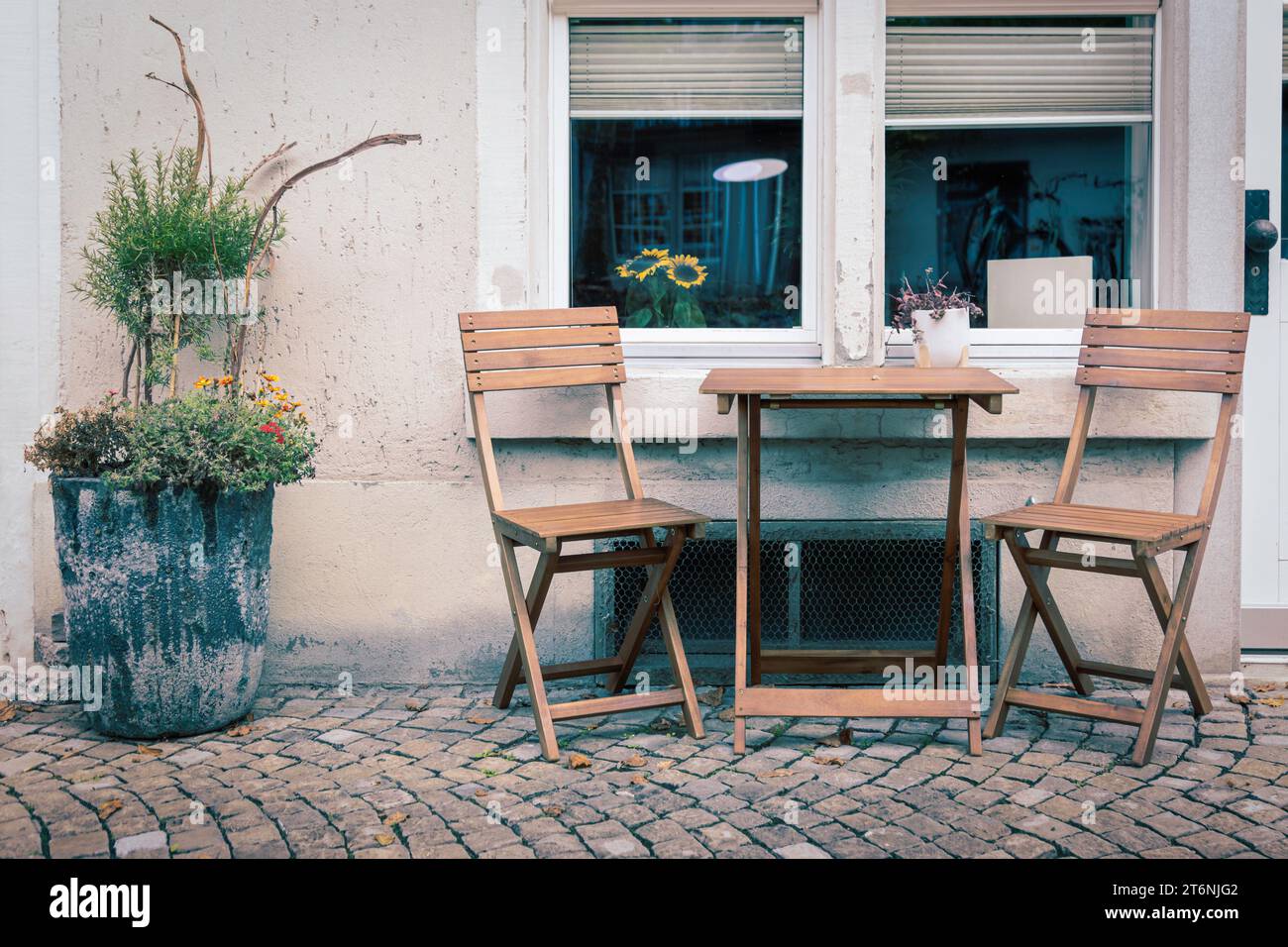 Table et chaises en bois devant un ancien appartement Banque D'Images Table et chaises en bois devant un ancien appartement Banque D'Images