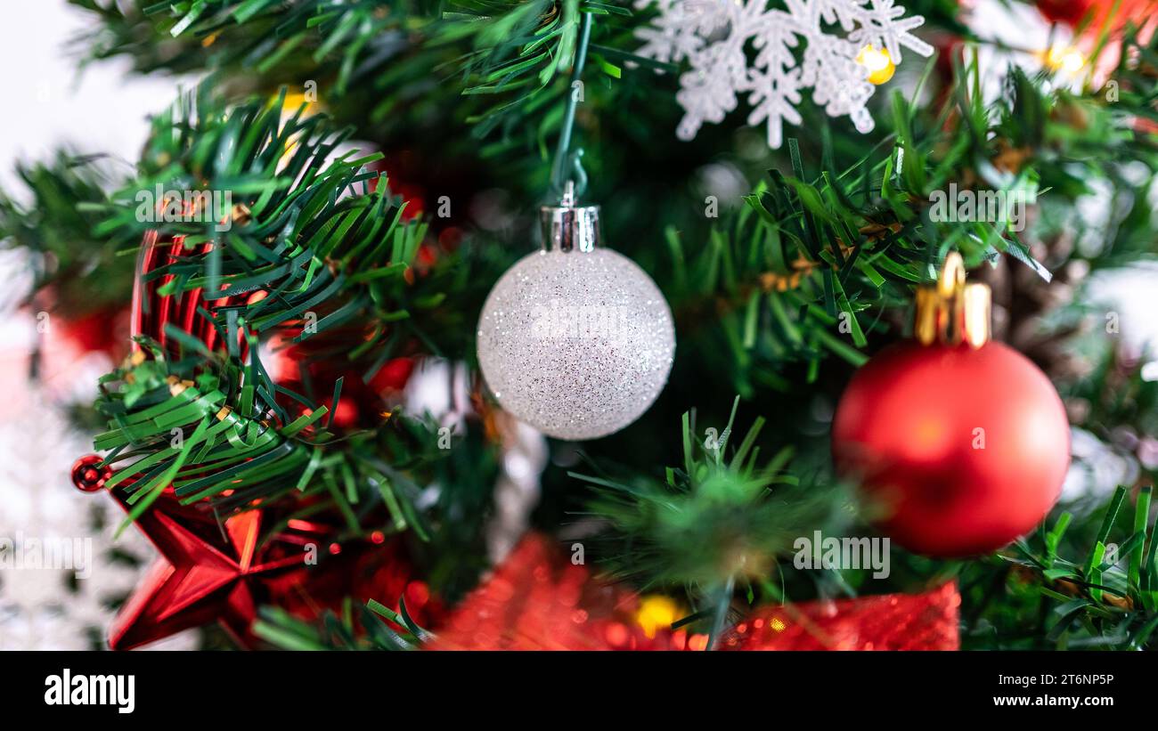 Les branches de sapin de Noël sont joliment décorées avec des boules de Noël, créant une ambiance festive avec les boules de Noël étincelantes. Banque D'Images