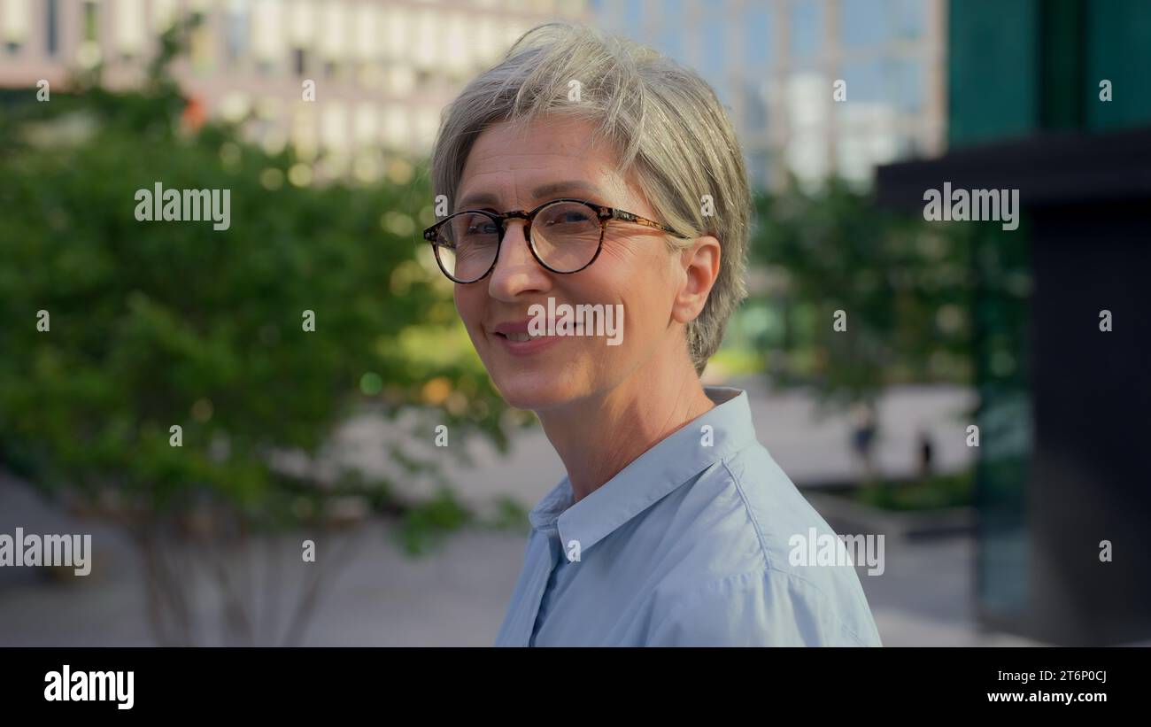 Portrait d'entreprise femme d'âge moyen femme d'affaires réfléchie vieille dame pensive regardant loin souriant inspiré femme mature profiter de la ville à l'extérieur heureux Banque D'Images